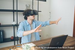 Male working in tech playing with VR glasses at home 56GGVP