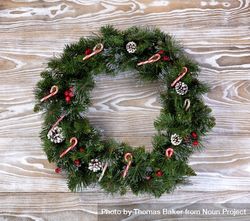Christmas wreath with lights and candy canes on wood 0KWeZ0