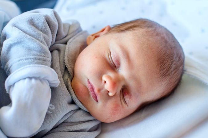 Newborn baby sleeping in its hospital crib