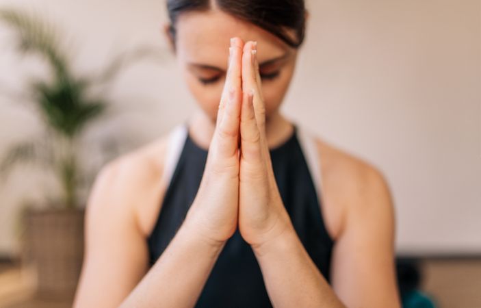 Woman in namaste yoga pose meditating