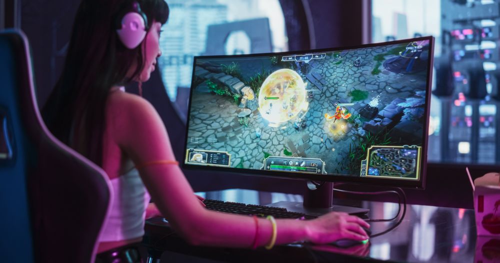 Excited Japanese Cosplay Woman Playing Online eSports Championship on a Desktop Computer