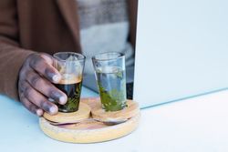 Crop Black man with espresso and glass of water in cafe