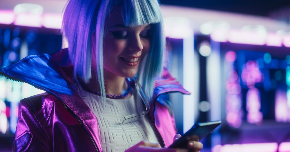 Portrait of a Stylish Cyberpunk Cosplay Girl with Blue Hair Using Smartphone.