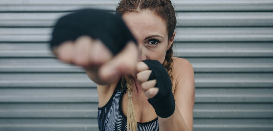 Sportswoman looking at camera and punching