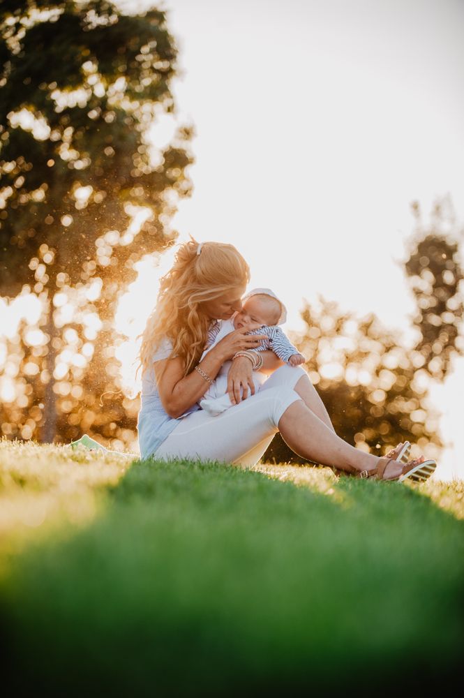 Grandma kissing his grandson with down syndrome in the park