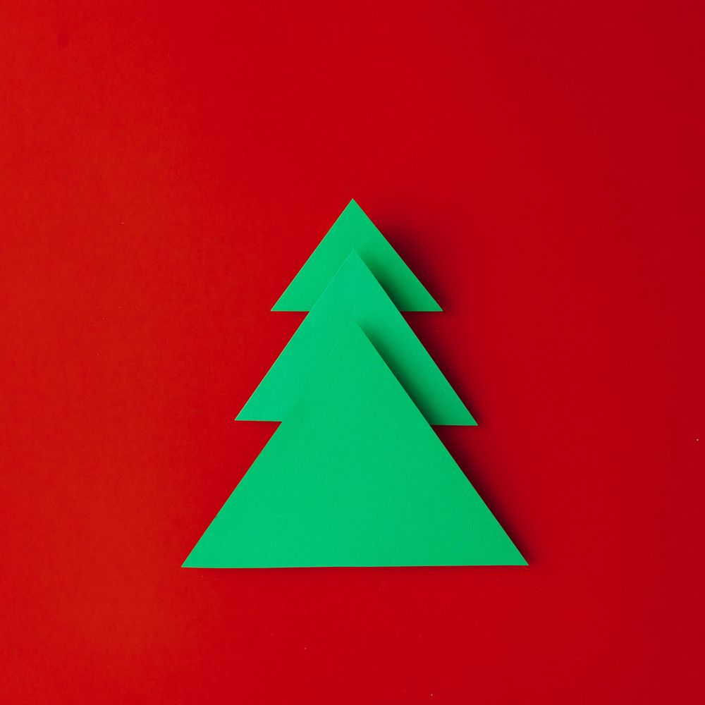 Minimal paper art style folded paper Christmas tree on red background