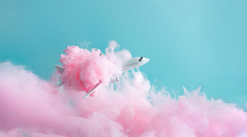 Cloud-like pink color paint with light  airplane on blue background