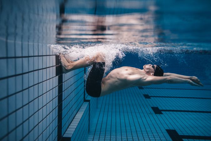 Male swimmer doing a flip turn underwater