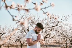 Bearded man meditating in spring garden