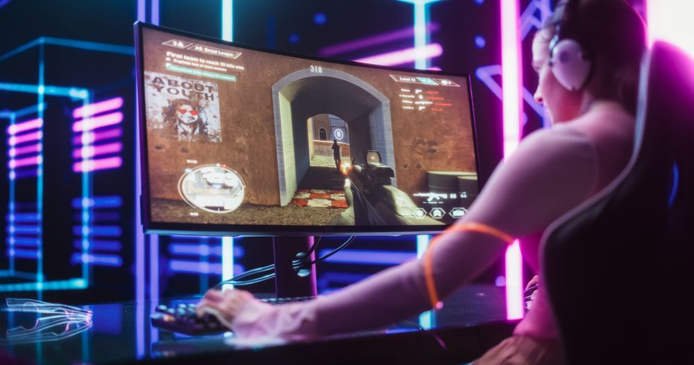 Over the Shoulder Footage of a Young Excited Gamer Smashing Competition in a First Person Shooter Game.