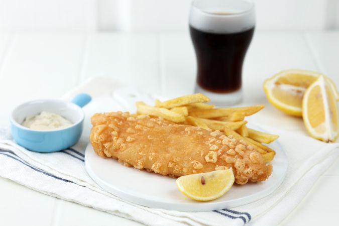 Fish and Chips Served with Lemon, Tartar Sauce and a Glass of Cola