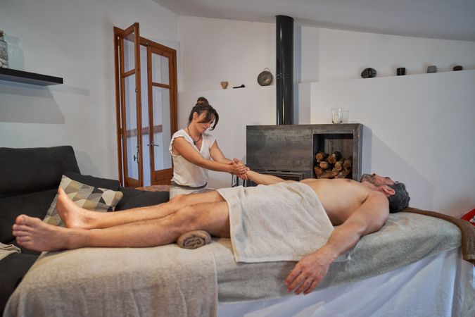 Masseuse massaging arm of male customer