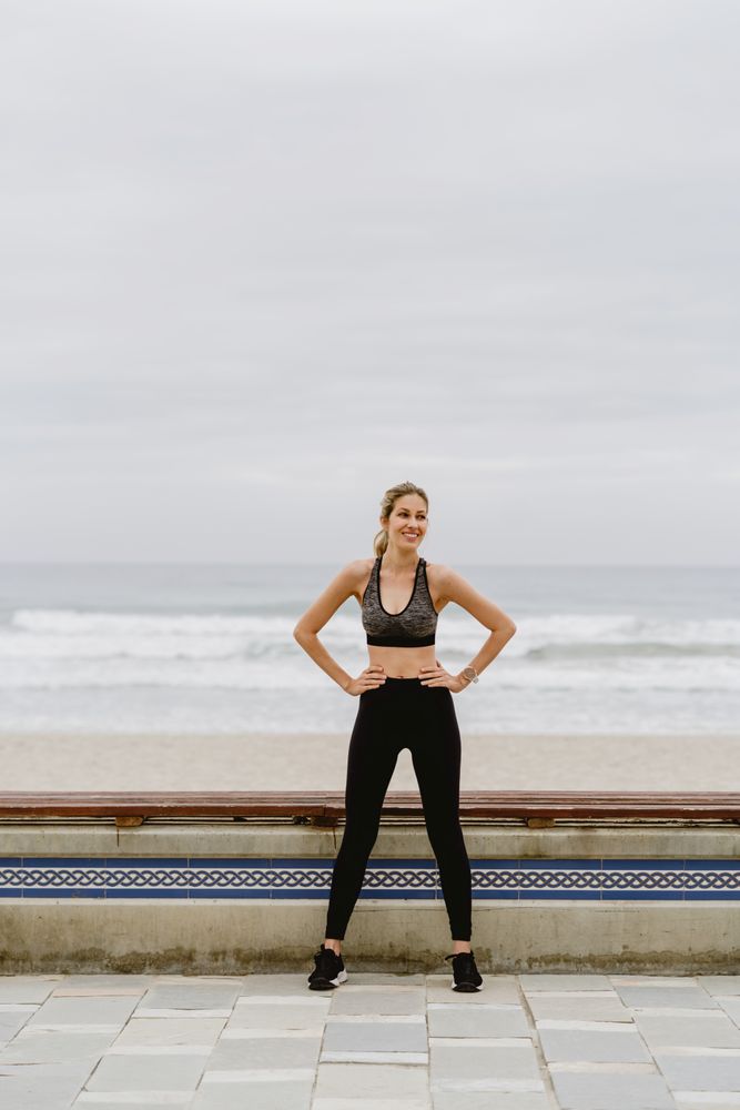 Woman in sports clothing stretching before exercise at seaside