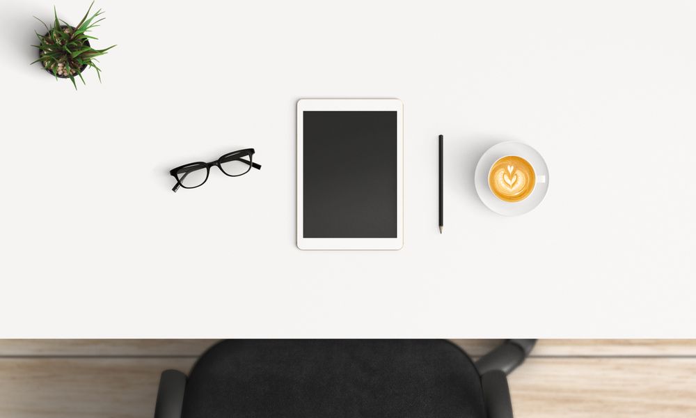 Modern workplace with coffee cup and smartphone or laptop copy space on table background. Top view. Flat lay style.