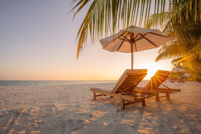 Reclining chairs on the beach with parasol