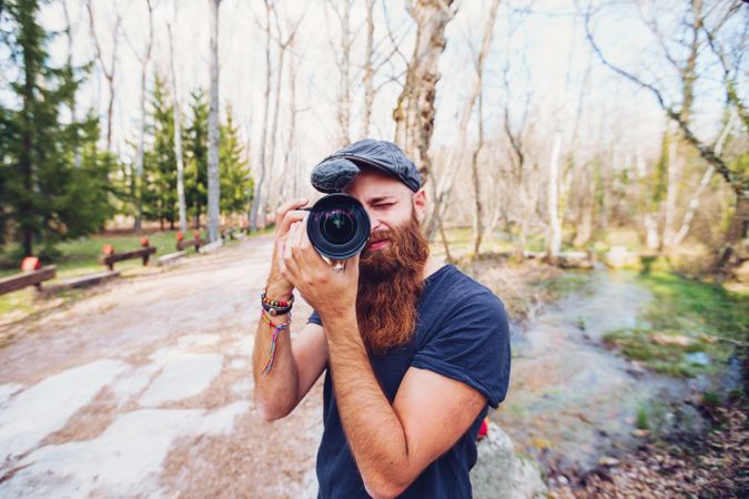 Hipster photographer taking picture in forest