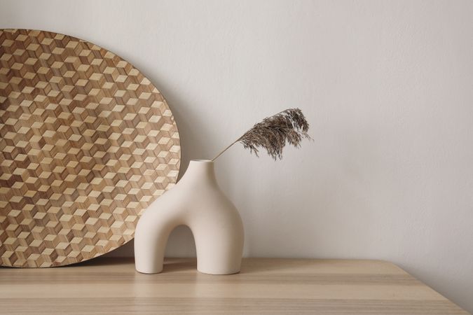 Vase with single branch on wooden table