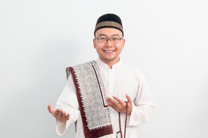 Asian Muslim man smiling doing greeting pose during Ramadan