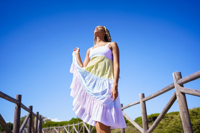 Carefree female playing with colorful dress on clear day