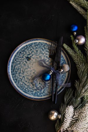 Christmas table setting with blue plate and ornaments
