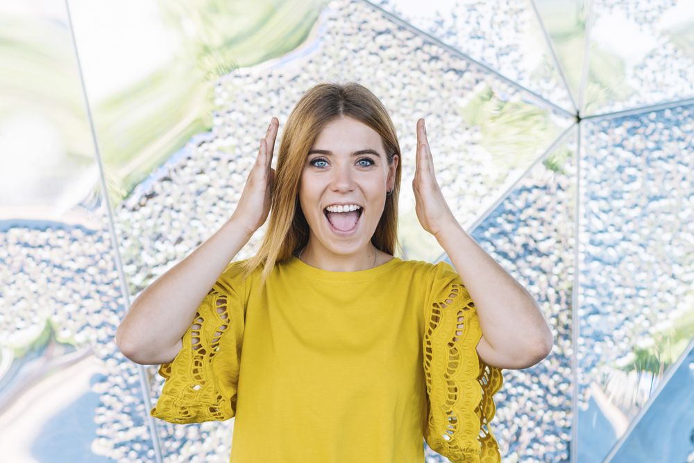 Young shy woman covering ears