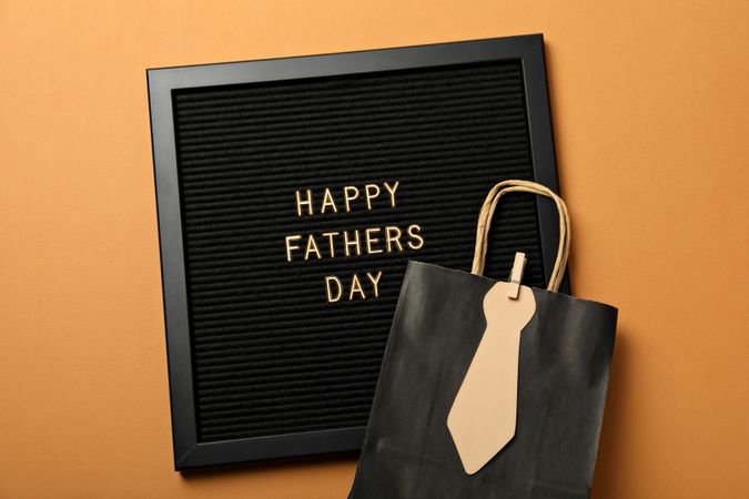 Inscription on a board for Father's Day, on an orange background.