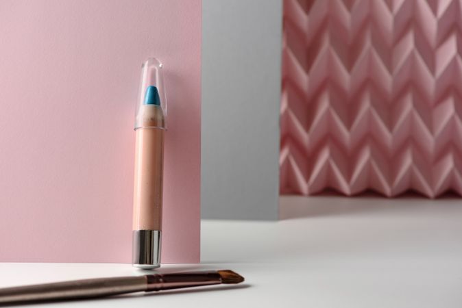 Cosmetic pencils:, make up blue eyeliner pencil, modern background with pink chevron reliefs. make up concept