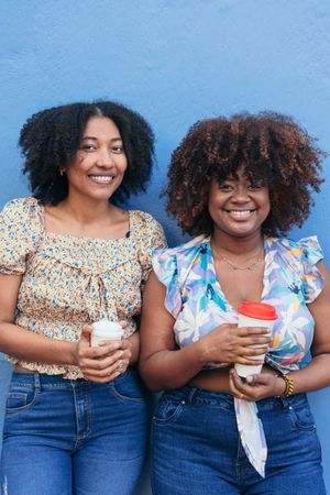 Two women drinking coffee in the street