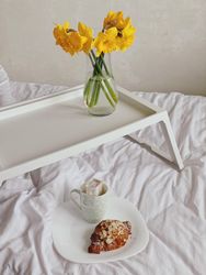 Plate with croissant on bed