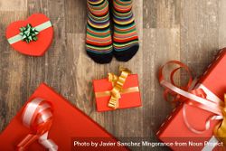 Christmas presents on wooden floor with small feet in socks bxJYd5