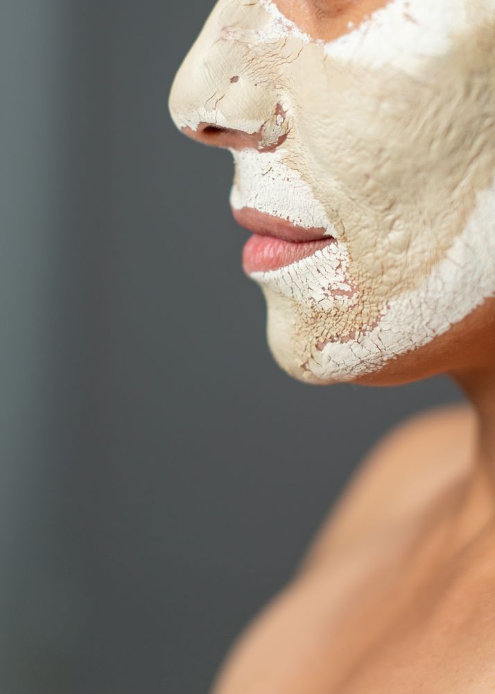 Crop woman with drying clay mask