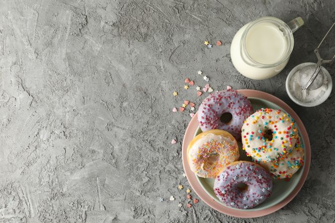 Concept of tasty food with donuts and milk on gray background