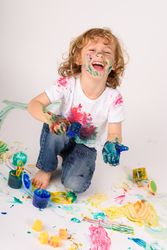 Positive boy covered with colorful paints