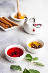 Tea cups on stone background with cinnamon and honey