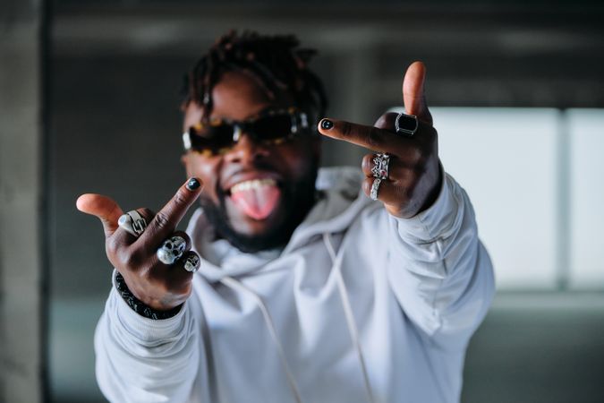 Cheerful stylish man showing middle finger