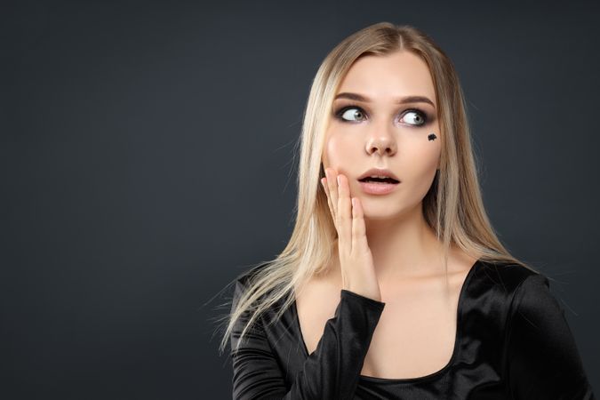 Concept of Halloween, young woman on dark background