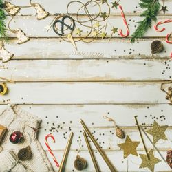 Decorations of stars, candy canes, scissors, candles on light background, square crop, copy space