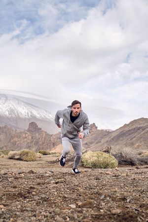 Concentrated man running on countryside road in highlands