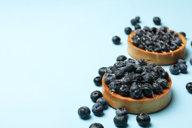 Blueberry pies on blue background, space for text