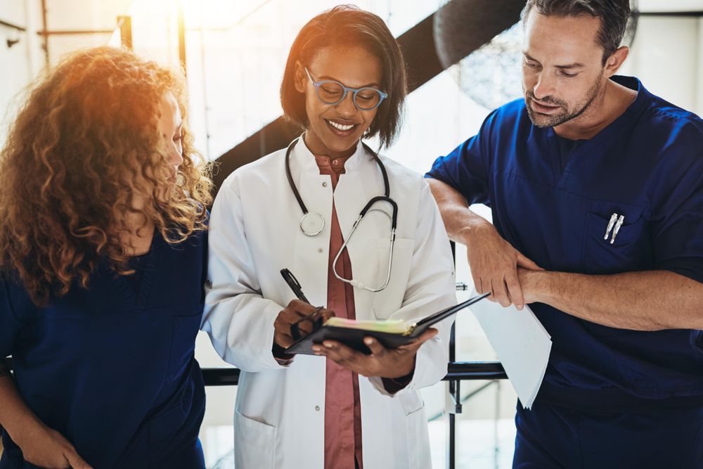Group of doctors and nurses taking notes in a hospital corridor