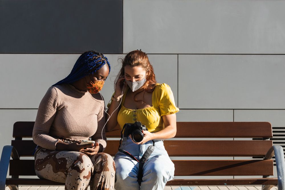 Cheerful multiethnic women looking through photos together