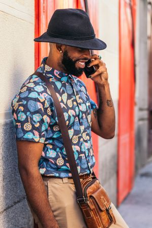 Stylish Black man talking on the phone outdoors in the city