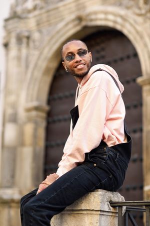 Happy male sitting outside a church in Spanish town