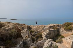 Unrecognizable female athlete exercising on cliff