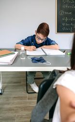Boy writing in his notebook at school