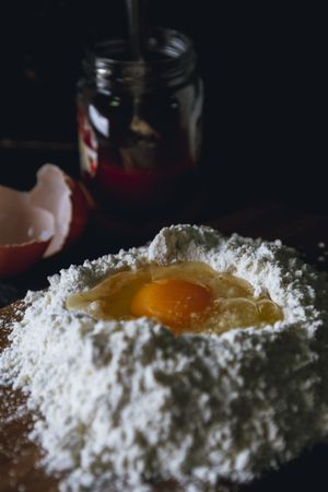 Broken egg and flour on dark background
