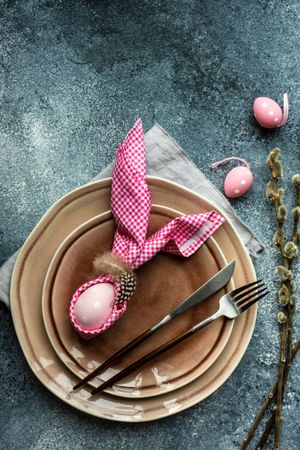 Easter holiday table setting with pink decorations with pink napkin on counter