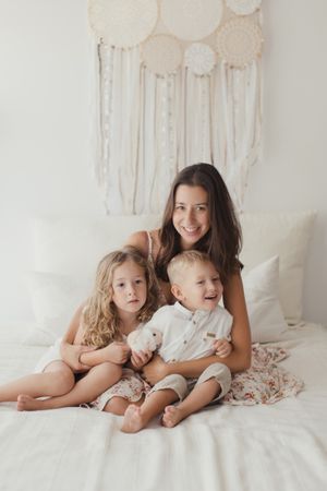 Content young mother with little kids at bedroom