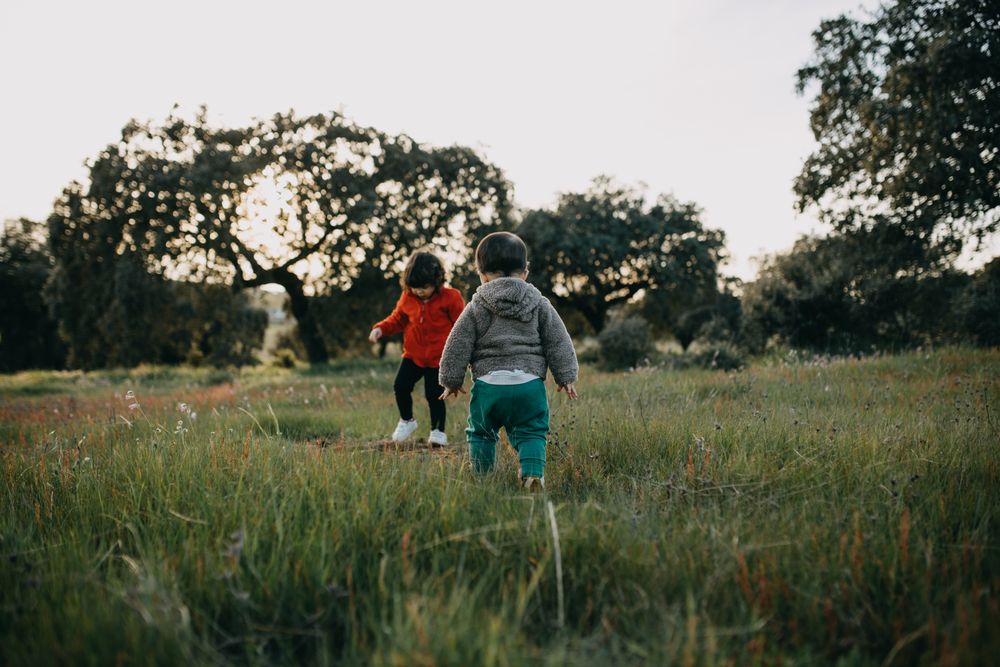 Brother and sister walking towards each other in a park