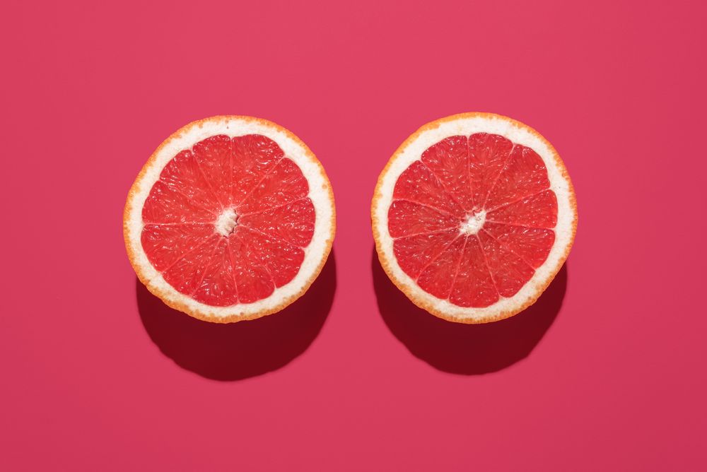 Grapefruit sliced in half minimalist on a magenta background